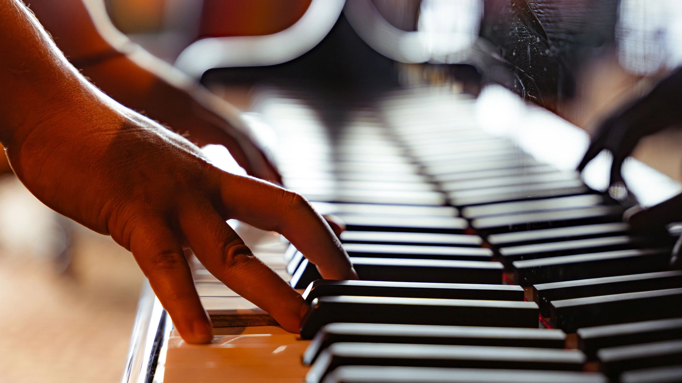 Hands playing piano keys creating music and melody